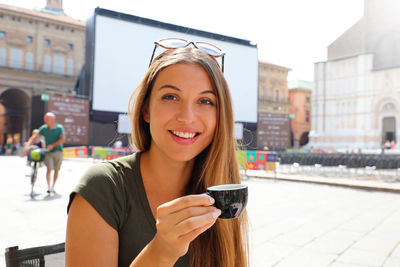 Portrait of smiling young woman in city
