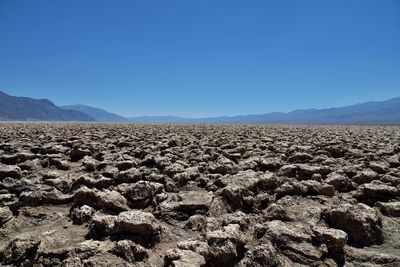 Scenic view of desert against clear blue sky