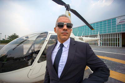 Portrait of man standing by helicopter