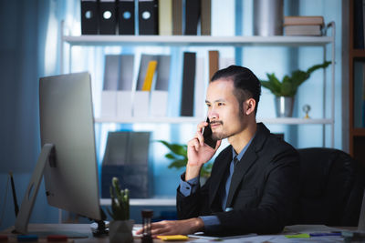 Man using mobile phone while sitting on table