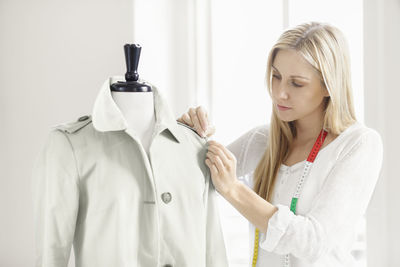 Woman preparing coat on mannequin