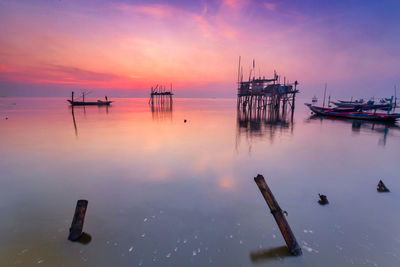 Sailboats in sea against sky during sunset