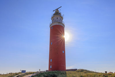 Lighthouse by sea against clear sky