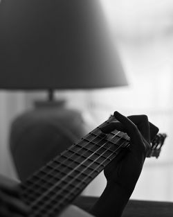 Cropped hand of person playing guitar at home