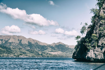 Scenic view of sea and mountains against sky