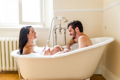 Young couple sitting in bathroom