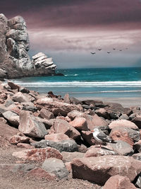 Rocks on beach against sky