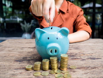 Close-up of hand holding coins on table