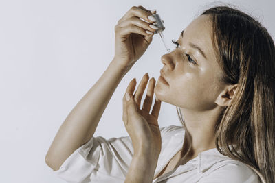 Skin care concept. beauty portrait of young woman girl holding pipette with cosmetic oil or serum 