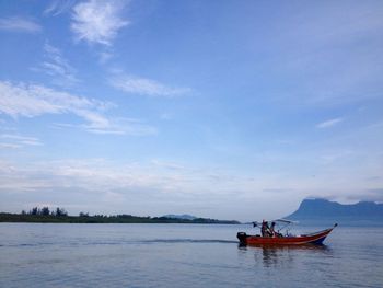 People in boat on sea against sky