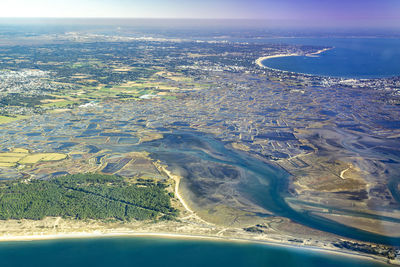 Aerial view of land and sea against sky