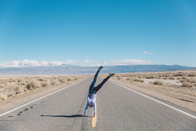 Woman doing handstand on road