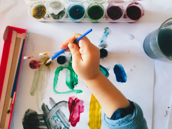 High angle view of kid hand painting