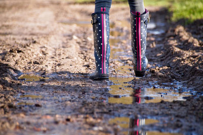 Low section of person walking on puddle