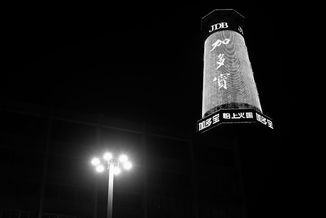 text, low angle view, night, illuminated, communication, western script, copy space, built structure, architecture, building exterior, clear sky, no people, lighting equipment, dark, information, outdoors, non-western script, capital letter, tower, close-up