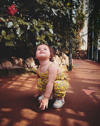 Full length of cute girl looking away against trees