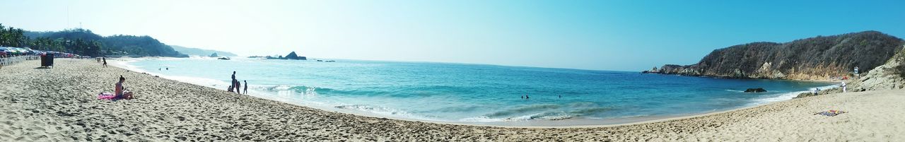 beach, sea, sand, blue, nature, travel destinations, sky, scenics, tranquility, vacations, beauty in nature, day, outdoors, water, coastline, tranquil scene, large group of people, mountain, landscape, people, tree, adult, adults only