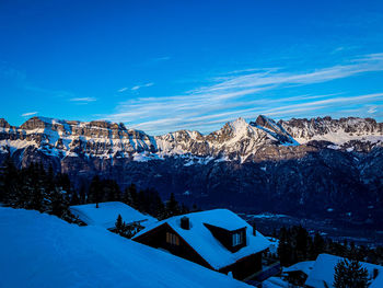 Scenic view of snowcapped mountains against blue sky