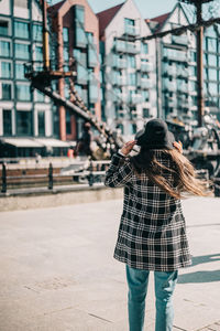 Rear view of woman walking on street in city