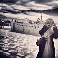 Silhouette of woman against cloudy sky