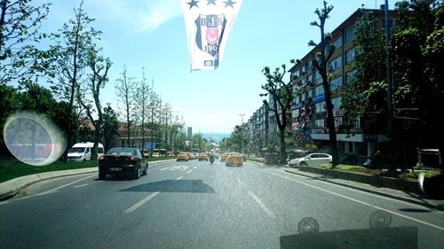 Cars on road against sky in city