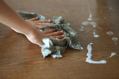 Low section of woman holding hands on table