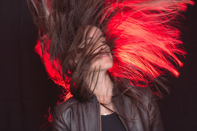 Portrait of woman with red hair against black background