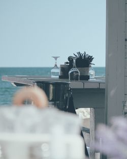 Rear view of man photographing sea against clear sky