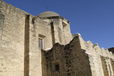 Low angle view of old building against clear blue sky