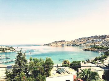 Scenic view of sea by city against clear sky