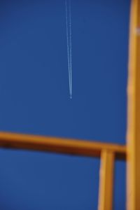 Low angle view of airplane flying against clear blue sky