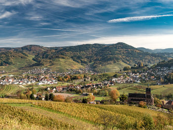 Scenic view of agricultural field and houses against sky