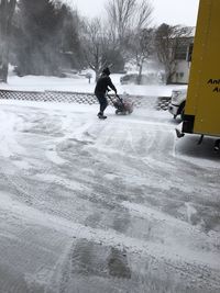 Rear view of man cycling on snow