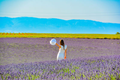 Woman standing on field against sky