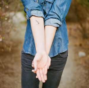 Midsection of woman with hands cupped standing outdoors