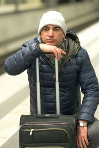 Man with luggage at railroad station platform