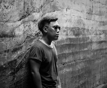 Portrait of young man standing against wall