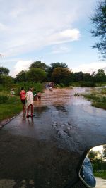 People in lake against sky