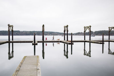 Wooden jetty in lake against sky