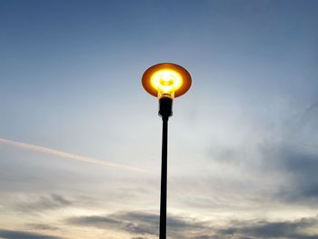 Low angle view of illuminated street light against sky