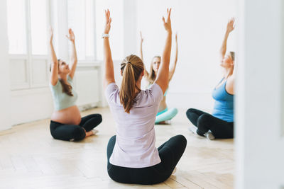 Full length of women exercising at gym