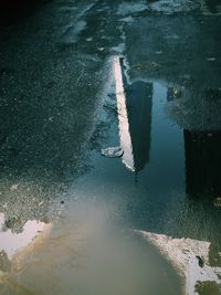 Reflection of one world trade center on wet road