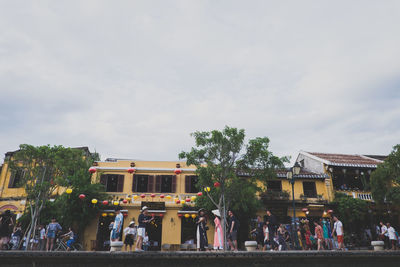 People in front of buildings against sky