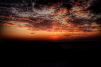 Scenic view of sea against dramatic sky during sunset