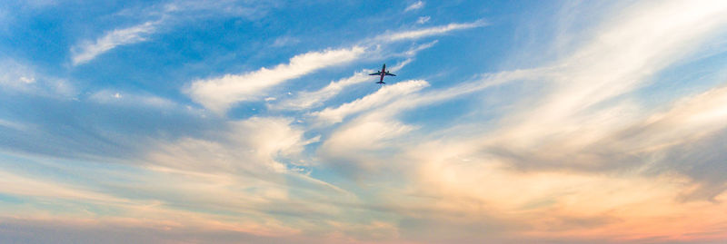 Low angle view of airplane flying against sky
