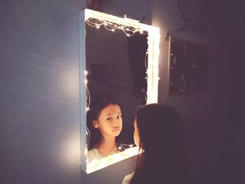 Portrait of girl in illuminated room at home