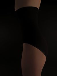 Close-up of woman against black background