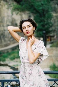 Young woman looking away while standing by railing