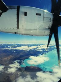 Close-up of airplane wing against blue sky