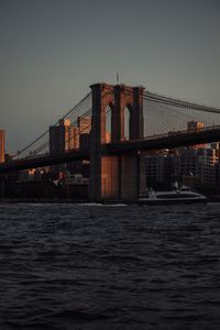 Illuminated bridge over river at night